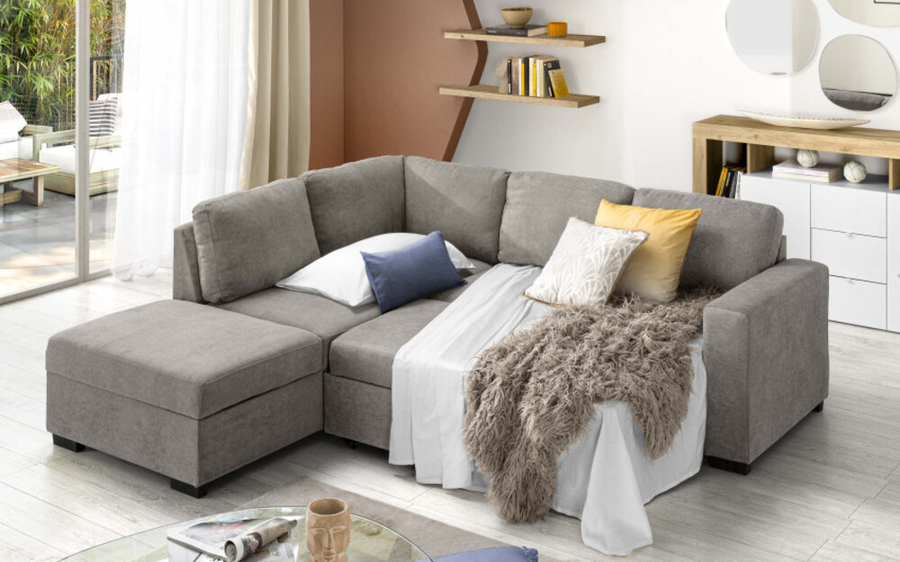 Divano letto angolare moderno in tessuto grigio scuro aperto con pouf